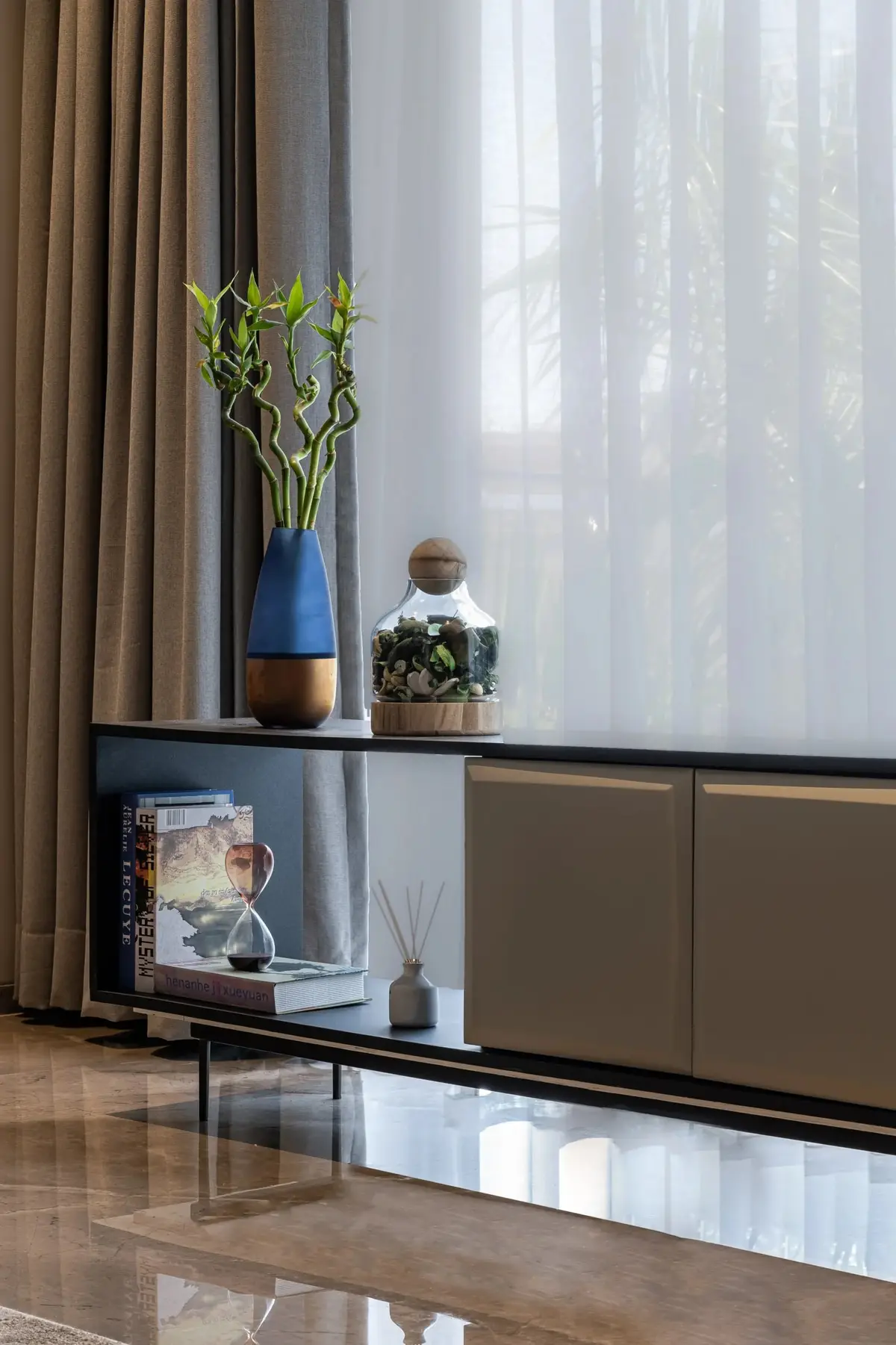 Bedroom console with sheer curtains and a planter by the window