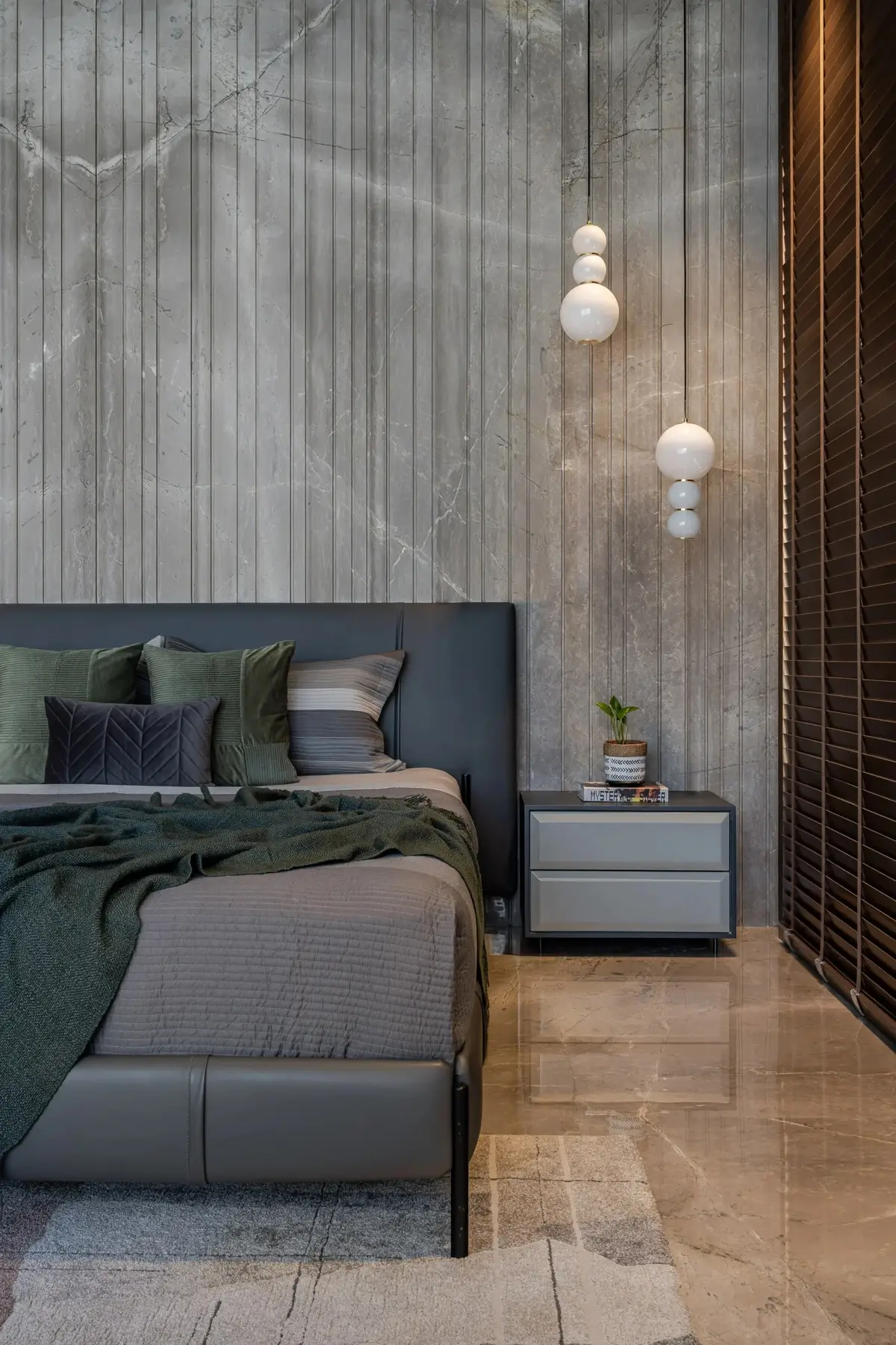 Bedroom with glass globe pendant lights against a grey stone wall