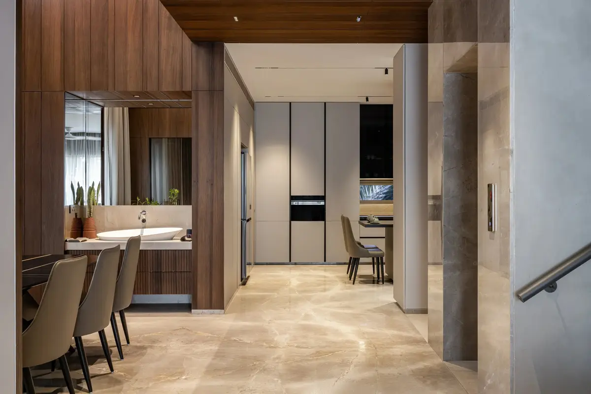Dining area with timber panelling leading to a modern kitchen