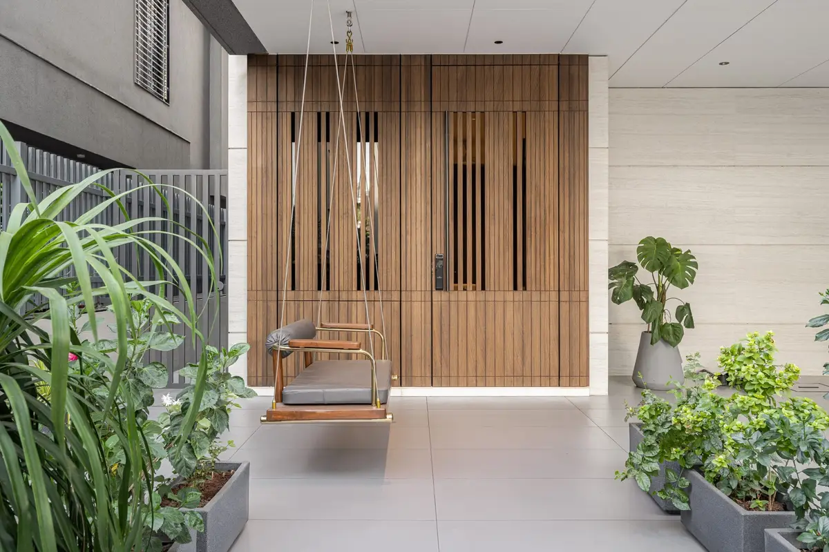 Entrance foyer with a timber slatted screen, a hanging swing and lush planters
