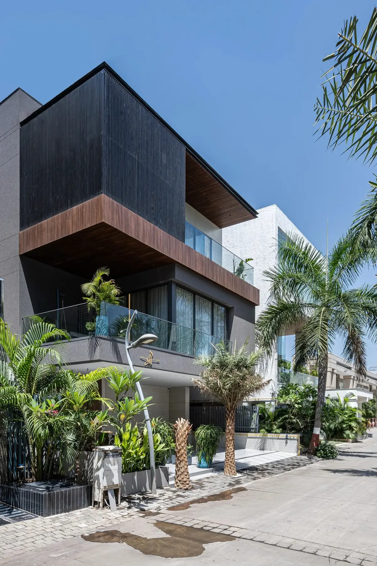 Side view of the bungalow showing layered balconies and landscaped frontage